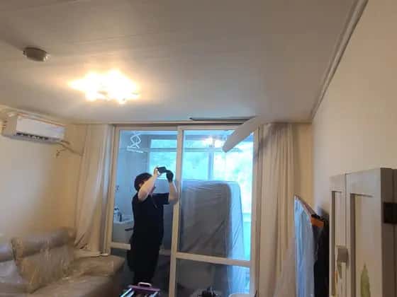 커튼을 걷고 창가에서 작업하는 모습