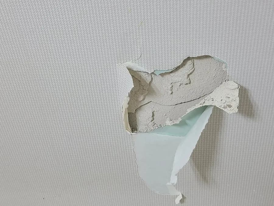 크게 파손되어 안쪽이 드러난 석고벽
